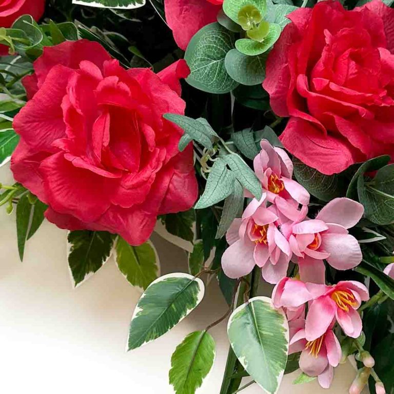 Stroik na cmentarz ze sztucznych kwiatów. Róże amarantowe i ostróżki różowe. Detal kompozycji. Kwiaty na całym obrazie. Zdjęcie-kwadrat-5.